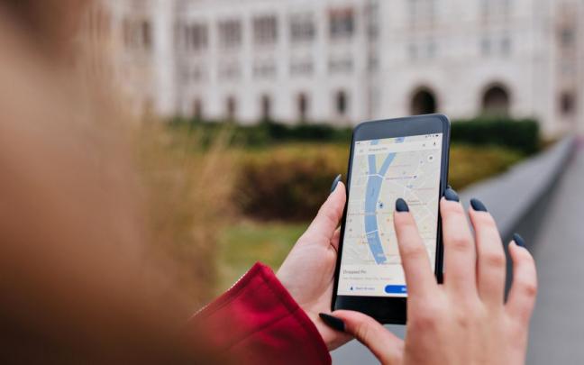 Una mujer usando Google Maps en una imagen de archivo. Una mujer usando Google Maps en una imagen de archivo.