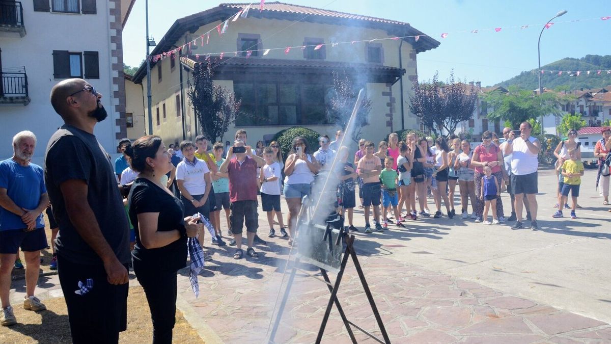 Zenia y Esteban atentos al cohete tras prender la mecha que daba comienzo a las fiestas.