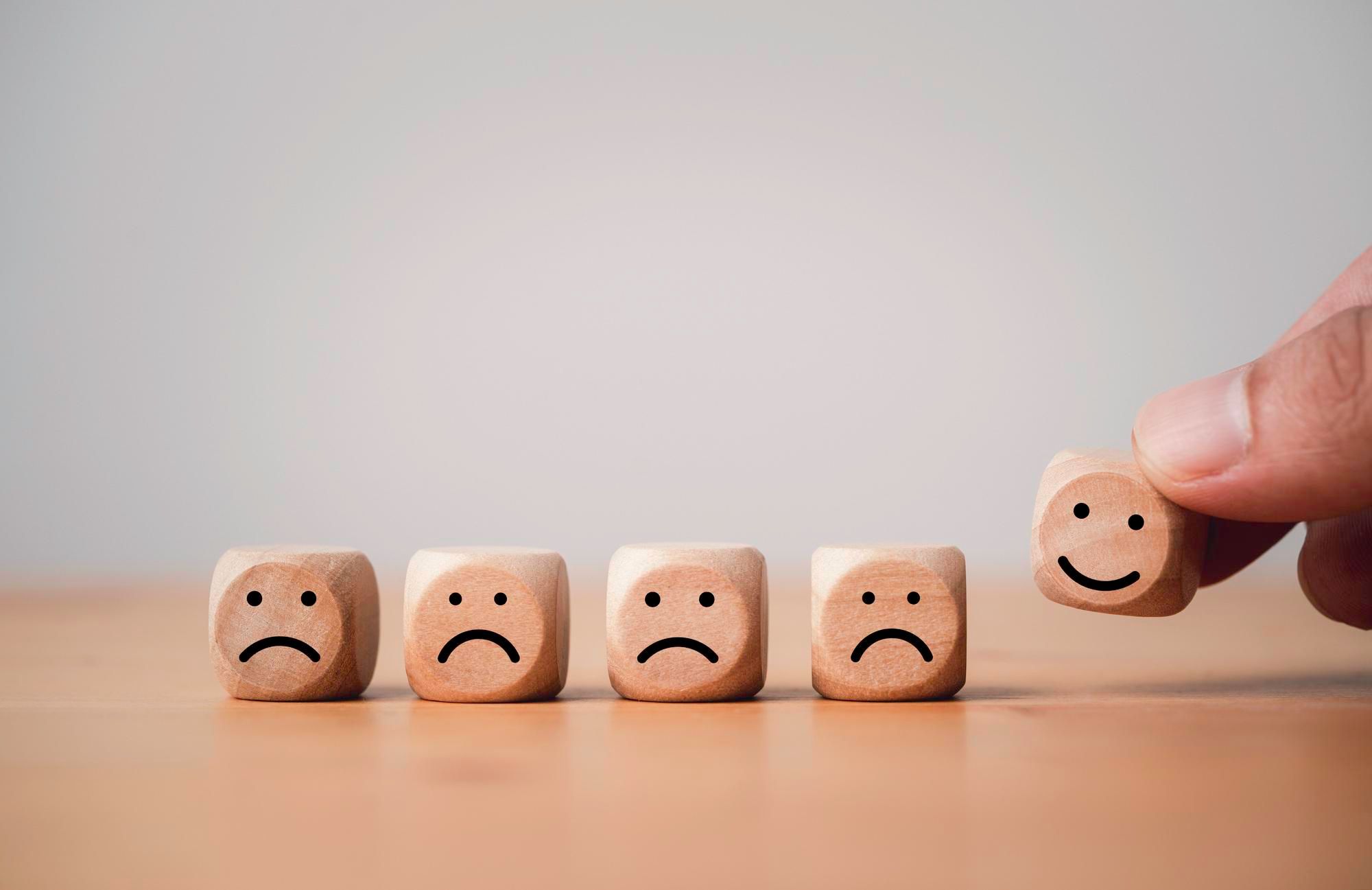 Pequeños cubos con caritas tristes y sonrientes.