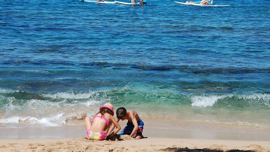 Dos niños disfrutando de la playa.