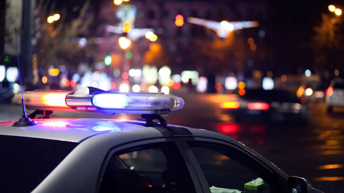 Un coche de la policía patrulla la ciudad por la noche.