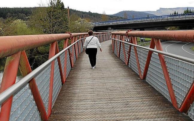 Una mujer caminando por el Parque Lineal del Nervión entre Amurrio y Laudio.