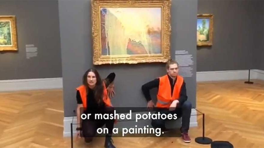 Los activistas junto al cuadro de Monet tras lanzarle puré de patata.