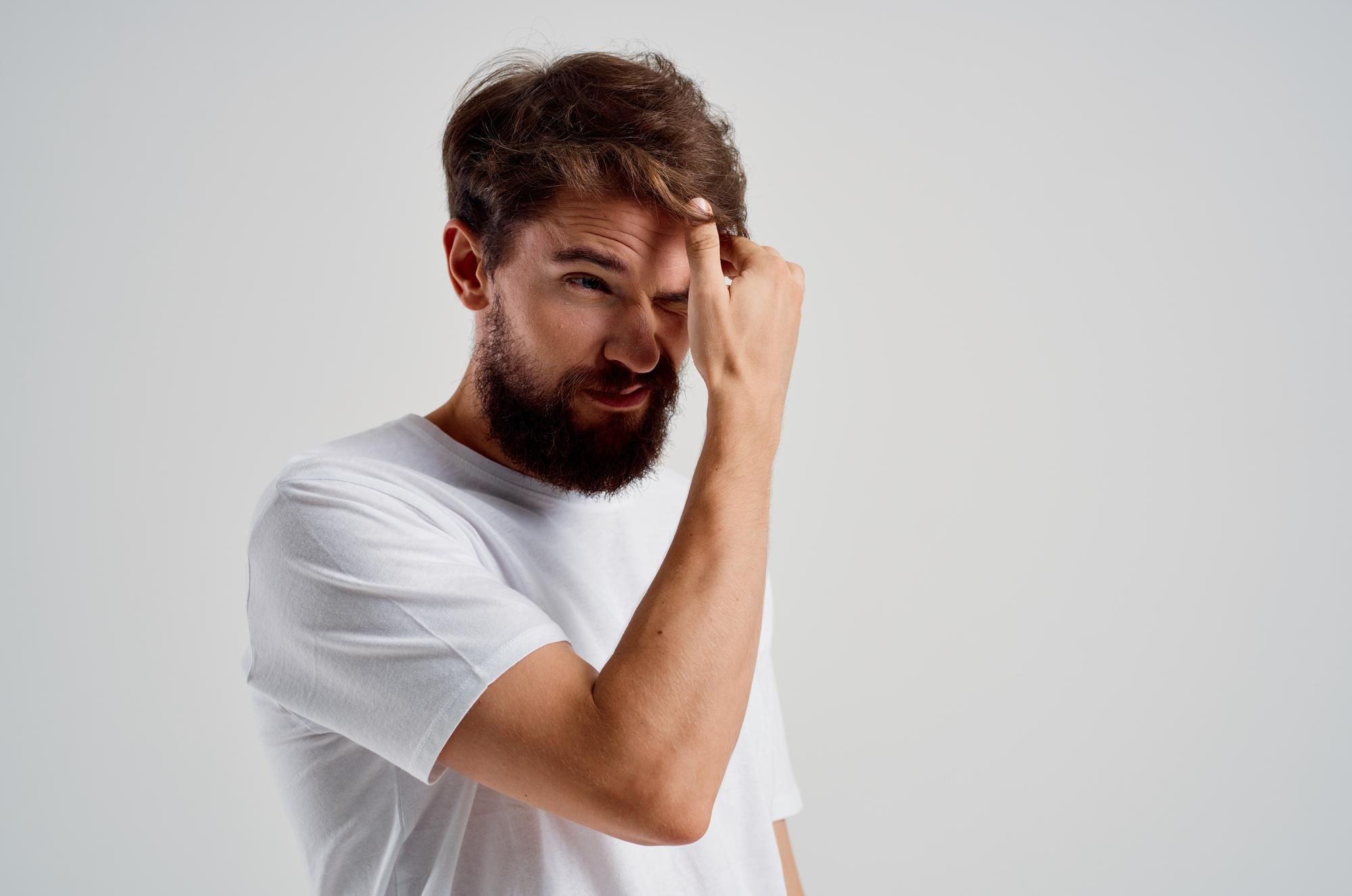 Un hombre con resaca y un fuerte dolor de cabeza.