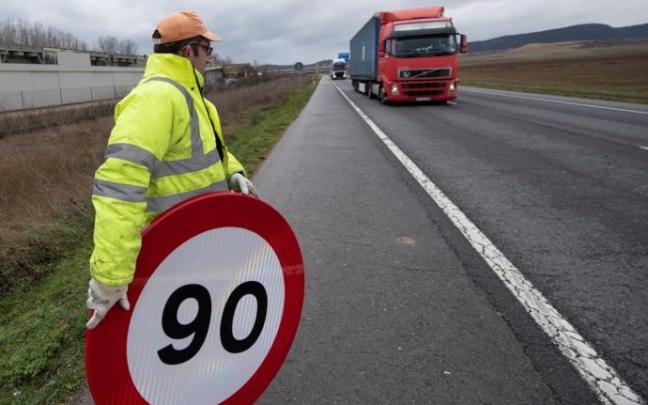 Un operario coloca una señal que limita la velocidad en la N-124.