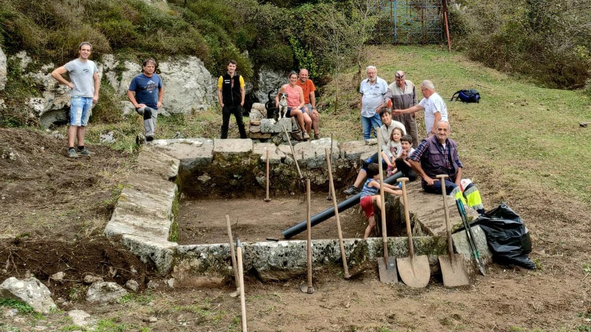 Algunos de los voluntarios posan ante el lavadero de El Saúco una vez rescatado del olvido.