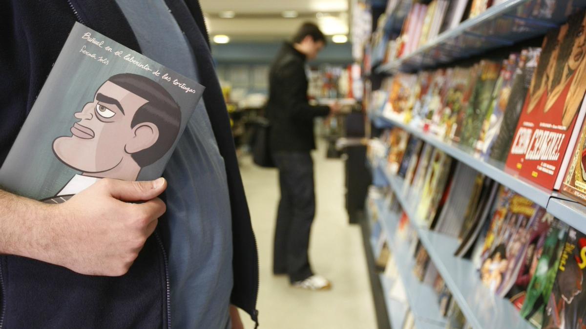 Un hombre sujeta un cómic en una librería.