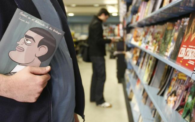 Un hombre sujeta un cómic en una librería.