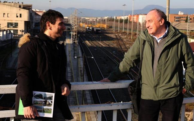 Mikel Santamaría y Juan Carlos Valerio, con la estación de Pamplona-Iruña de fondo, dialogan sobre la estrategia ferroviaria más idónea para Navarra.