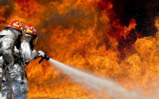 Bomberos intentando sofocar un incendio, en una imagen de recurso.