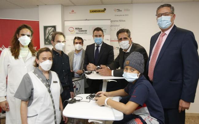 Participante del estudio, acompañado por Miguel Induráin y profesionales y representantes de la Clínica Universidad de Navarra, el Banco Santander y Dualebike.