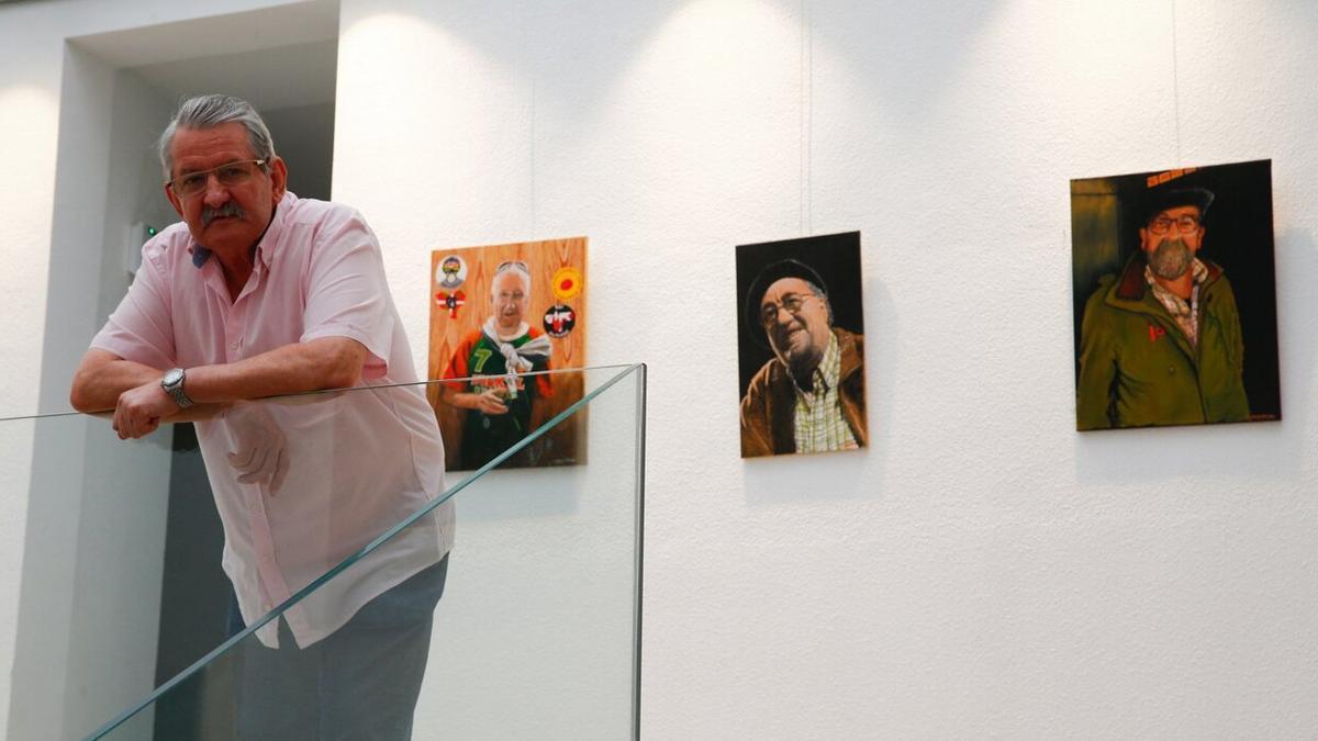 Álvaro Mundiñano, en verano de 2021 junto a algunos de los retratos que expuso en Plazara!