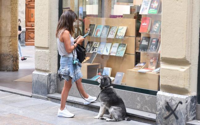 Emakume bat, liburudenda baten erakusleihoaren aurrean.
