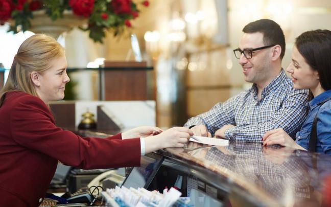 Una pareja hace el check-in en la recepción de un hotel. Una pareja hace el check-in en la recepción de un hotel.