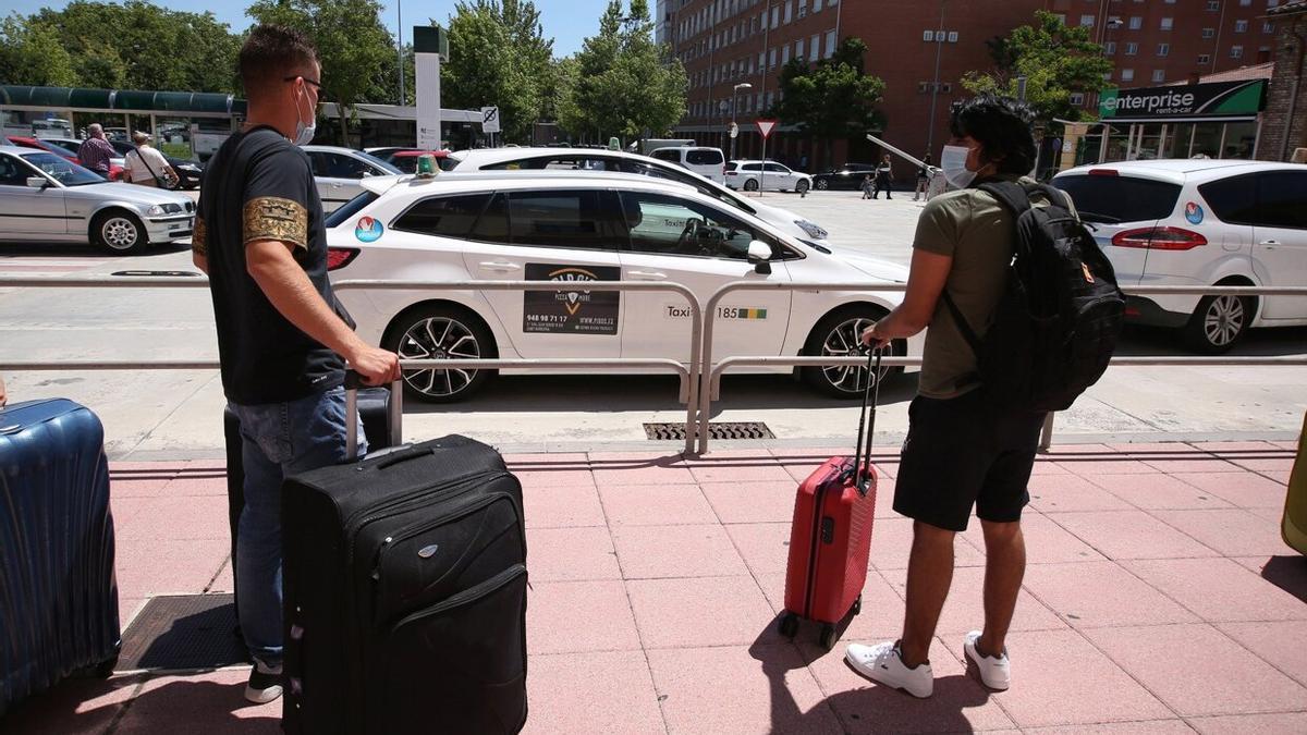 Personas junto a la parada de taxis de la estación de tren.