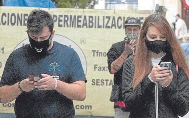Telefono mugikorra erabiltzen duten gazte batzuk kaletik ibiltzen. Telefono mugikorra erabiltzen duten gazte batzuk kaletik ibiltzen.