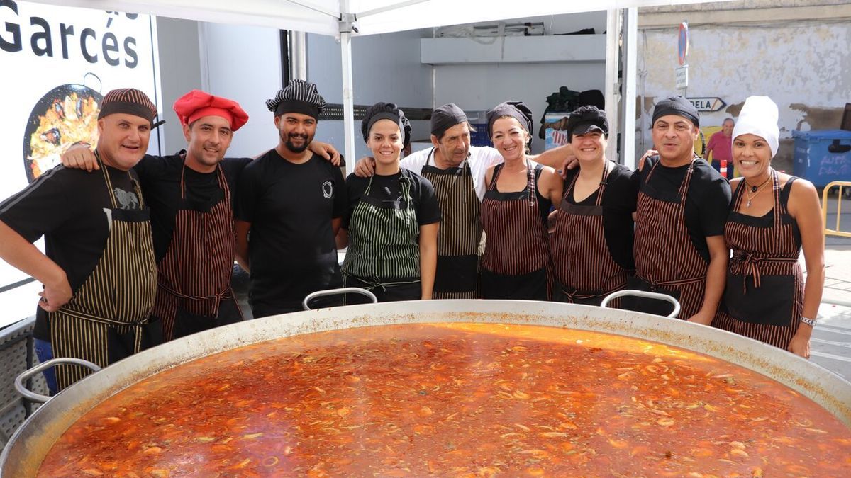 Los encargados de hacer la comida posan antes de echar el arroz.