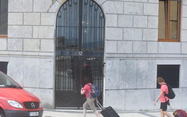Turistas llegan al portal número 12 de la calle Moraza de Donostia, donde se ofertan pisos turísticos.