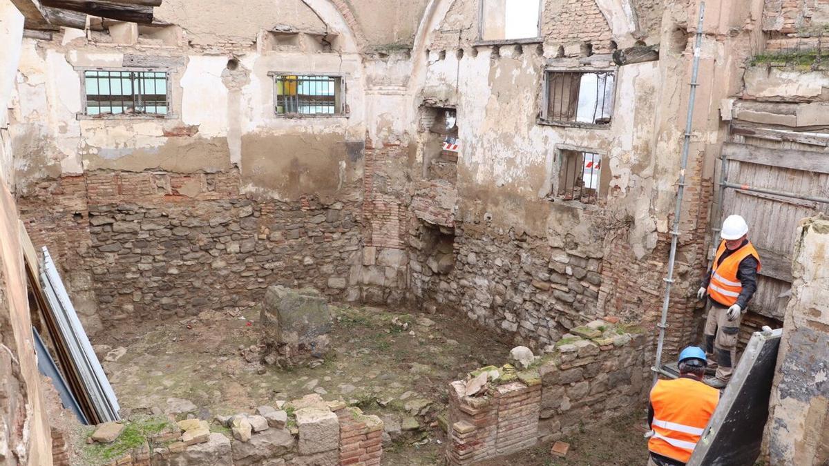 Dos trabajadores de Valuarte colocan andamios dentro de los restos del Humilladero