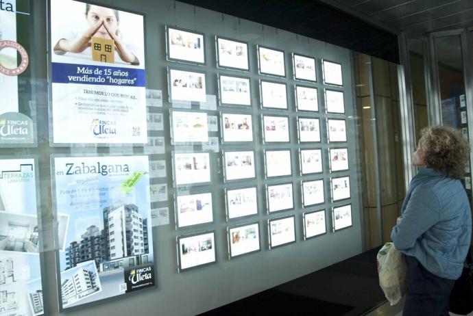 Una mujer observa las opciones de vivienda en una inmobiliaria de Vitoria.