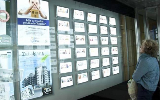Una mujer observa las opciones de vivienda en una inmobiliaria de Vitoria. Una mujer observa las opciones de vivienda en una inmobiliaria de Vitoria.