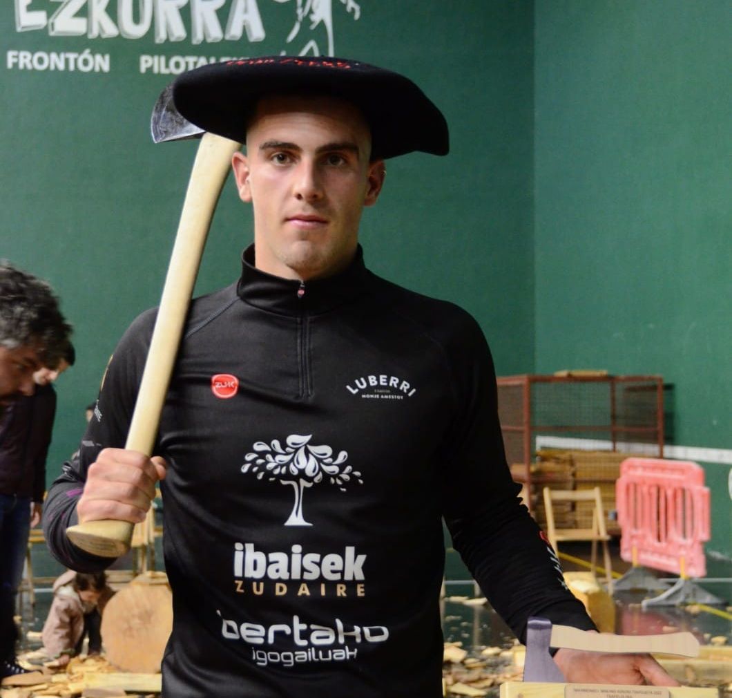 El aizkolari de Otsagabia, Iker Vicente, con la txapela y el trofeo.