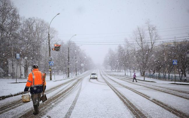 Un coche circula por una v&iacute;a nevada.