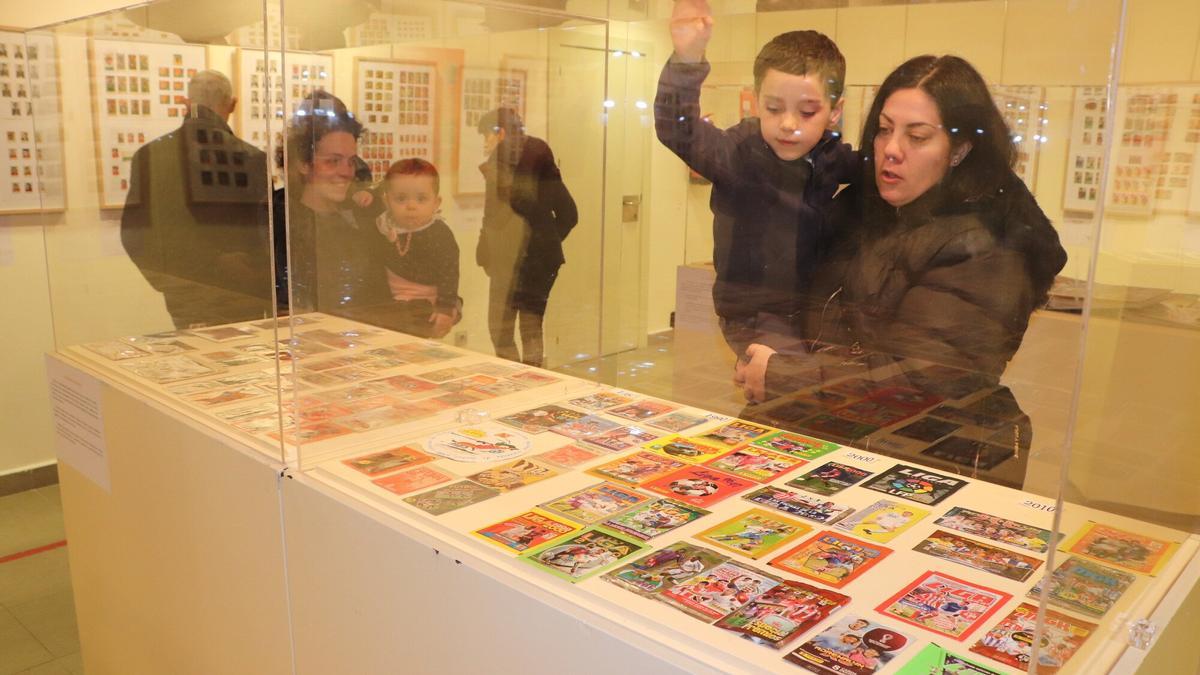 Un niño y una niña de Castejón observan la colección de cromos.