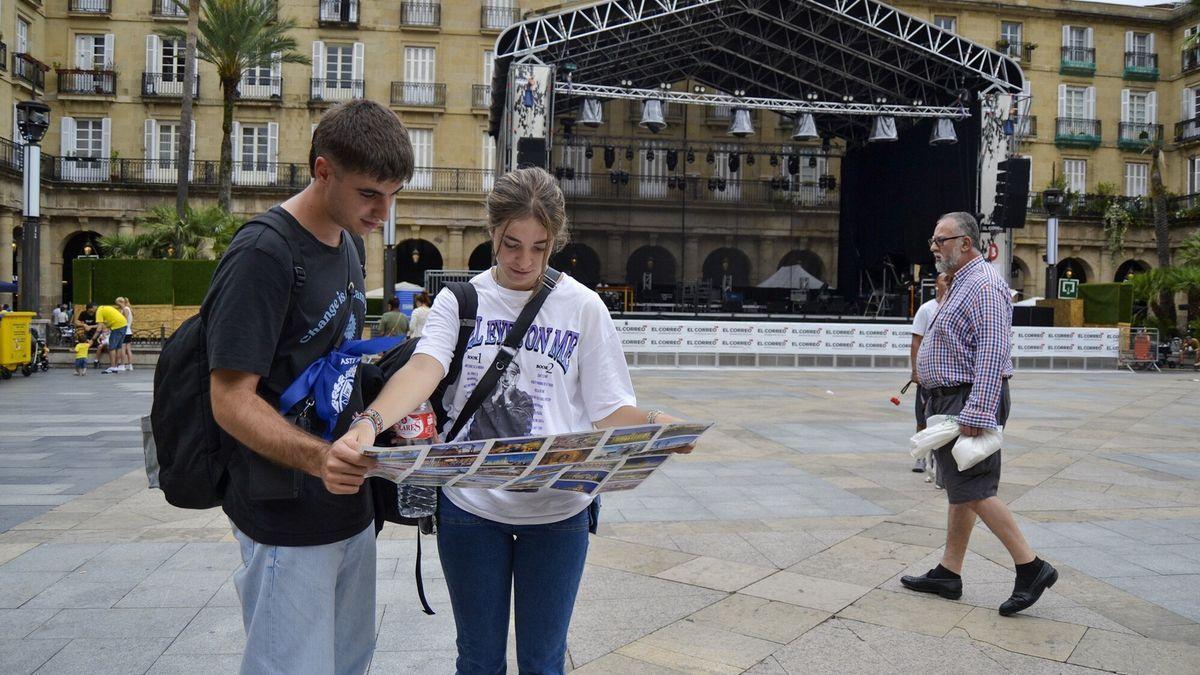 Unos jóvenes turistas escudriñan un plano de Bilbao en la Plaza Nueva