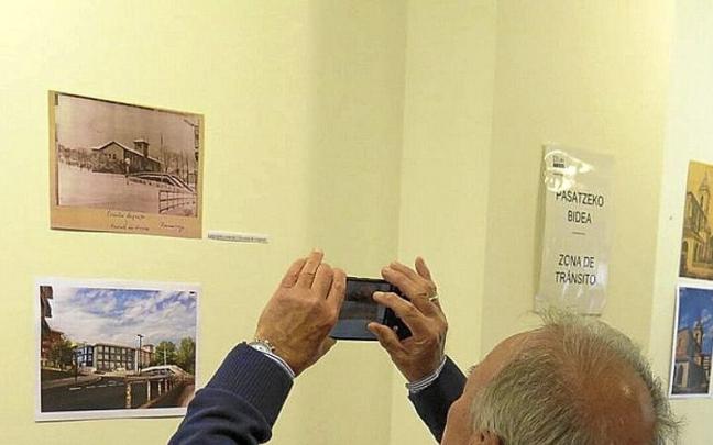 Bizilagun bat, erakusketako argazkiei argazkiak ateratzen.