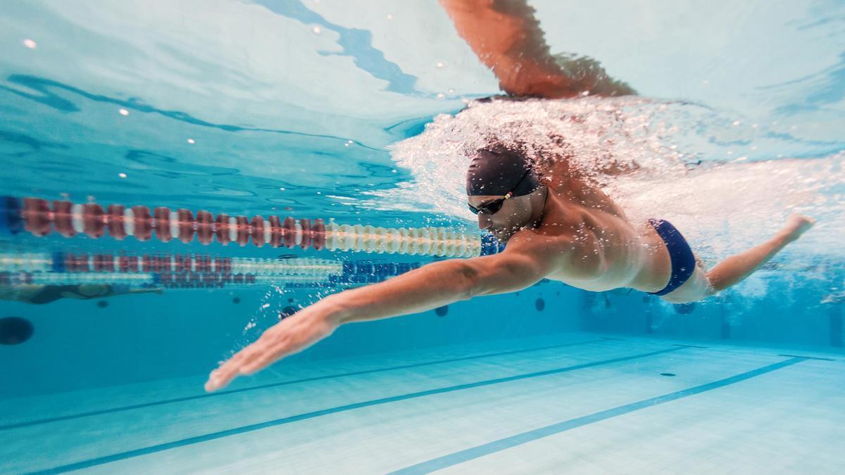 Un hombre nada en una piscina olímpica.