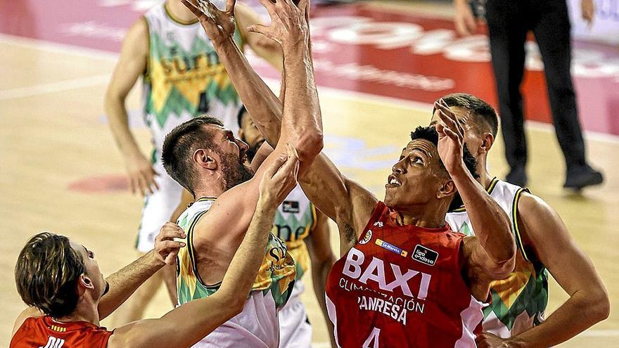 Jeff Withey trata de levantar el balón bajo el aro del Manresa ante la oposición de Tyson y Jou. | FOTO: ACB PHOTO/J. ALBERCH