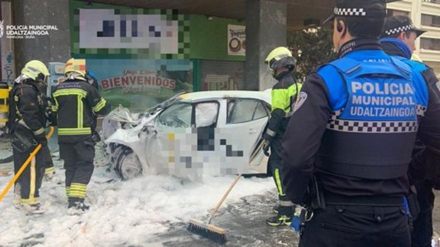 Bomberos y policías junto al coche accidentado.