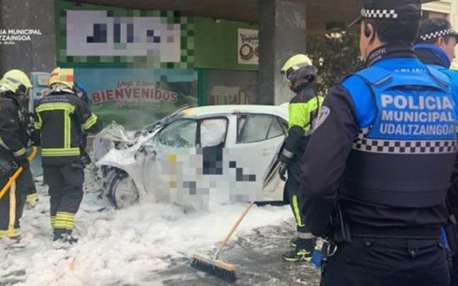 Bomberos y policías junto al coche accidentado.