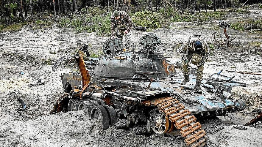 Soldados de las fuerzas ucranianas inspeccionan un tanque ruso destruido en los combates.