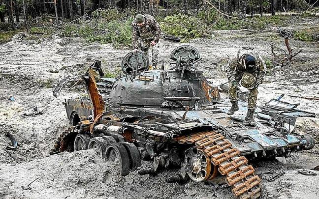 Soldados de las fuerzas ucranianas inspeccionan un tanque ruso destruido en los combates.