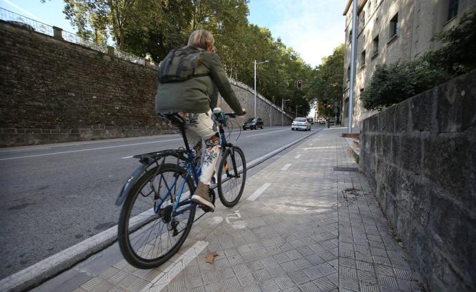 Un ciclista circulando por el carril bici pintado en la acera de Labrit.