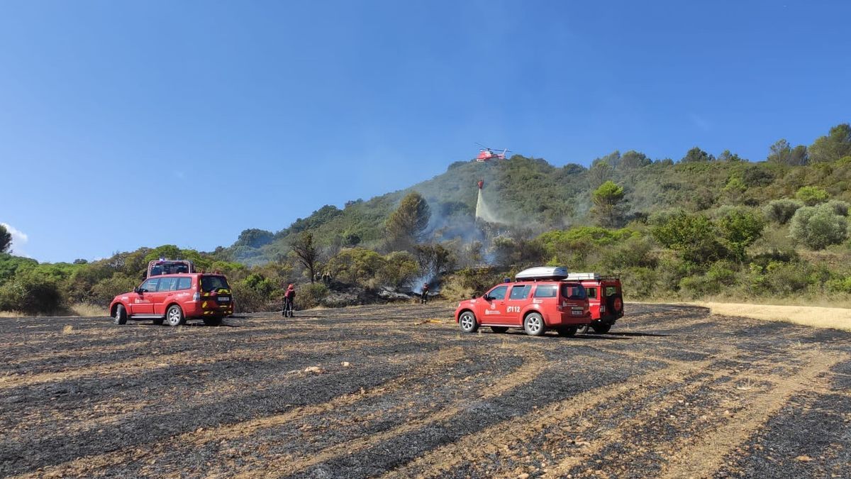 El helicóptero y los bomberos trabajan en la extinción del fuego.