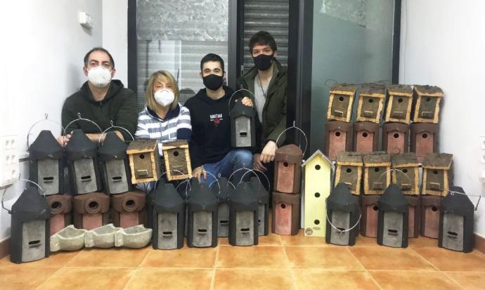 Miembros de Otsoaren Taldea posan con las casetas que van a repartir por terrenos privados en Zalla.