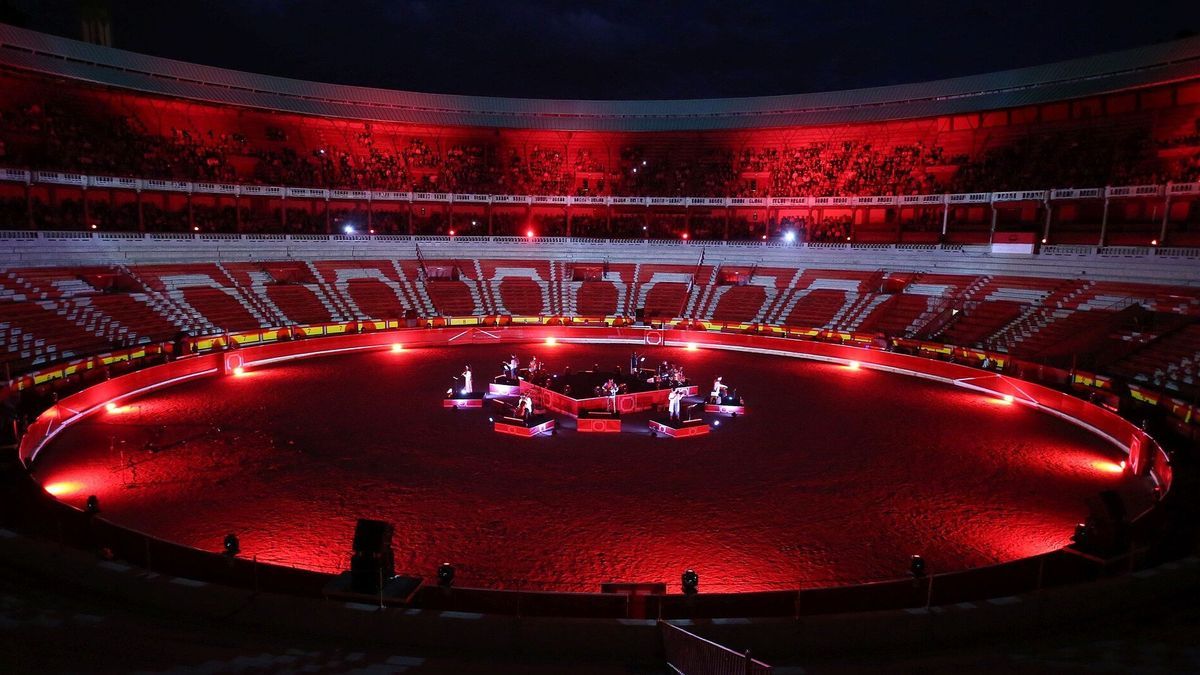 Un momento de la actuación del grupo Suakai con violines y violonchelos en una plaza de toros teñida de rojo.