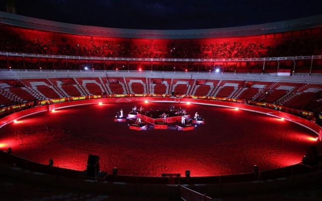 Un momento de la actuación del grupo Suakai con violines y violonchelos en una plaza de toros teñida de rojo.