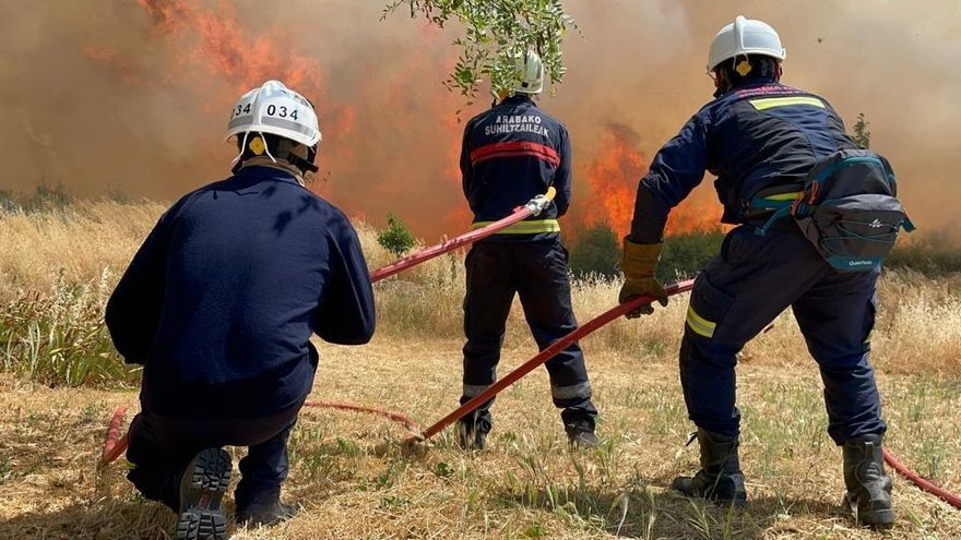 Varios bomberos acometen las llamas de un incendio.