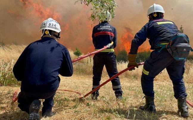 Varios bomberos acometen las llamas de un incendio.