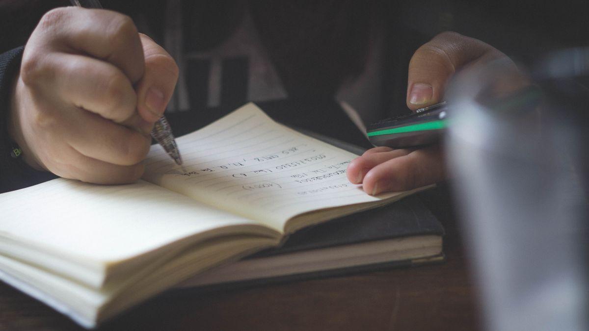 Una persona escribe en un cuaderno de notas.