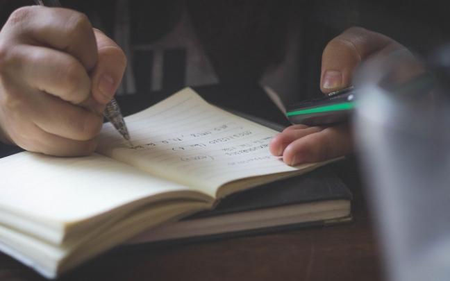 Una persona escribe en un cuaderno de notas.