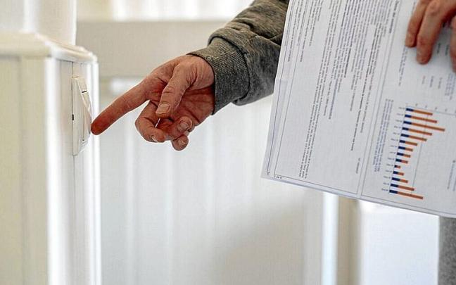 Un hombre apaga un interruptor con una factura de luz en la mano en una foto de archivo. | FOTO: E. P.