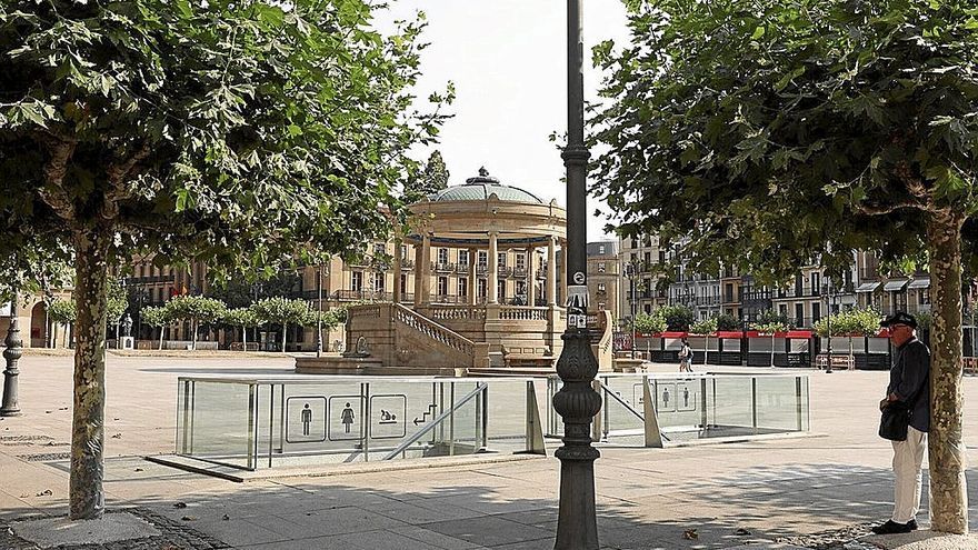 Un hombre mayor busca la sombra de un árbol en un día caluroso.