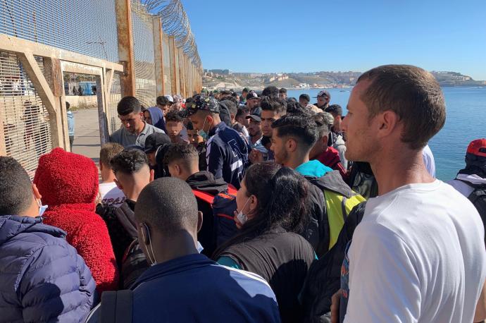 Un grupo de personas tratan de cruzar la valla fronteriza