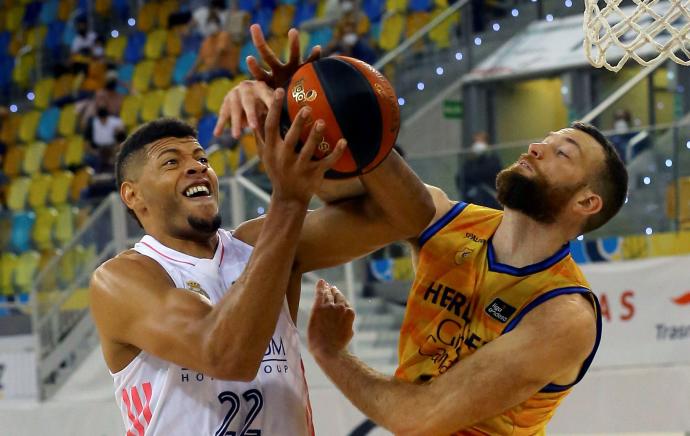 El pívot caboverdiano del Real Madrid Walter Tavares (i) y el jugador estadounidense del Herbalife Gran Canaria, Matt Costello, disputan el balón durante el segundo partido de los Playoff.