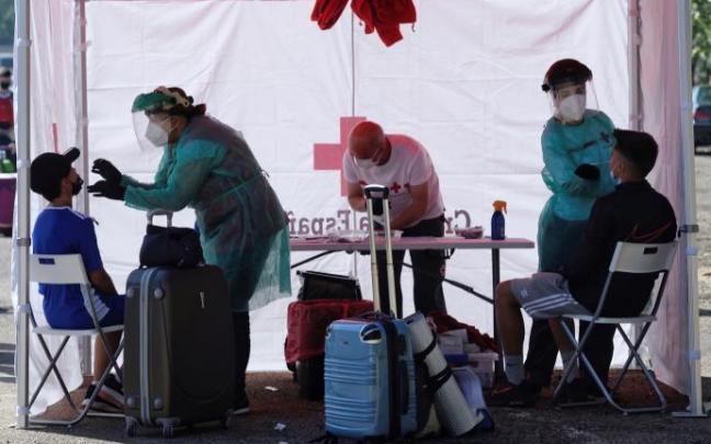 Varios trabajadores de Cruz Roja realizan una prueba PCR a un joven Varios trabajadores de Cruz Roja realizan una prueba PCR a un joven